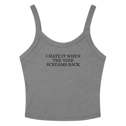 "I hate it when the void screams back" printed on a athletic heather women's micro-rib tanktop laying on a flat surface amongst sunglasses and shorts