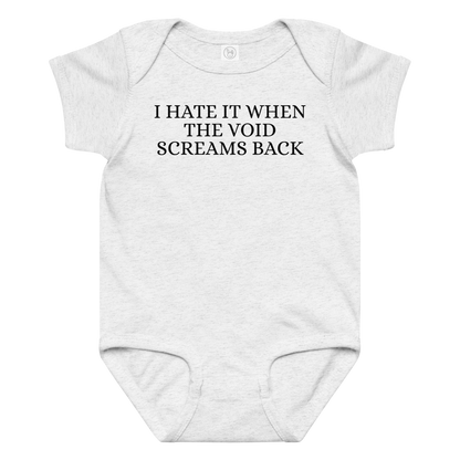 "I hate it when the void screams back" printed on a ash baby jersey bodysuit laying on a flat surface amongst other clothes