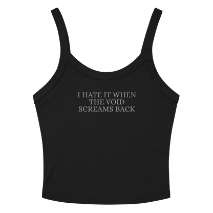 "I hate it when the void screams back" printed on a solid black blend women's micro-rib tanktop laying on a flat surface amongst sunglasses and shorts