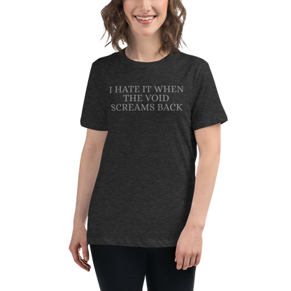 "I hate it when the void screams back" printed on a dark grey heather women's relaxed t-shirt worn by a female