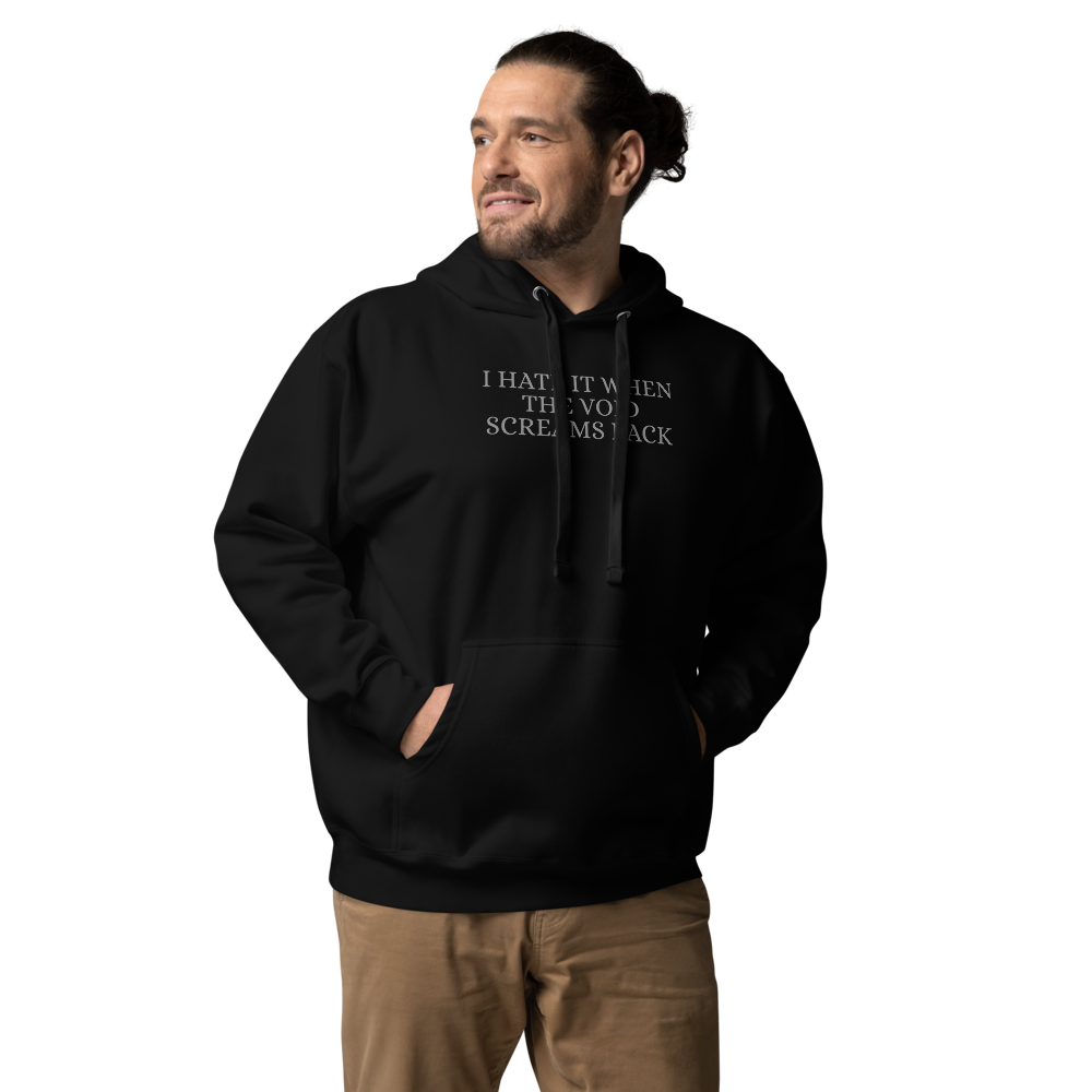 "I hate it when the void screams back" printed on a black unisex hoodie worn by a male