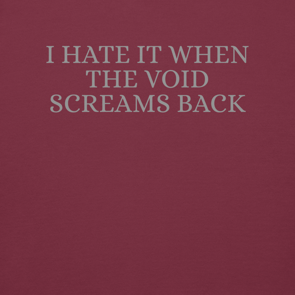 "I hate it when the void screams back" printed on a maroon background
