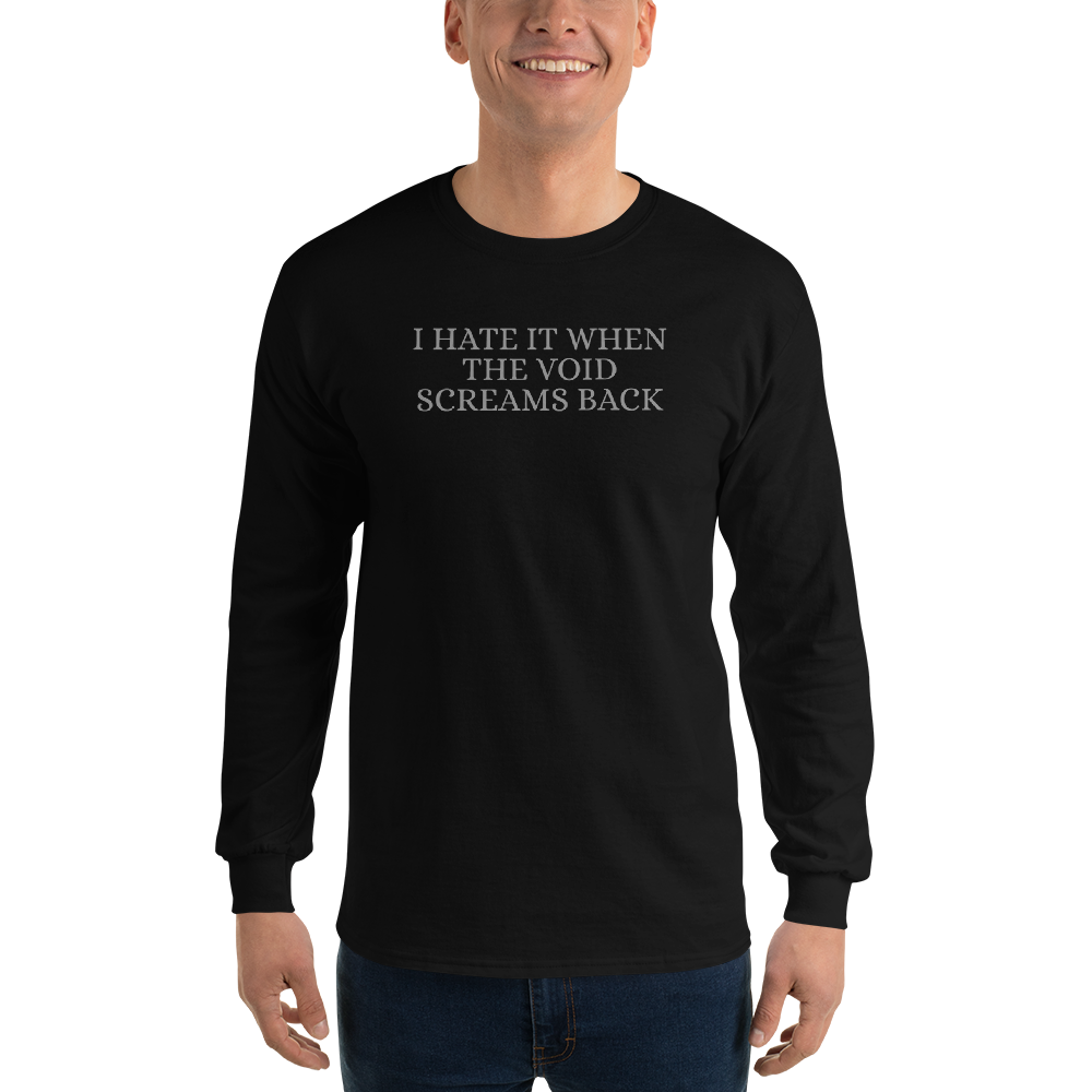 "I hate it when the void screams back" printed on a black men's long sleeve shirt worn by a male