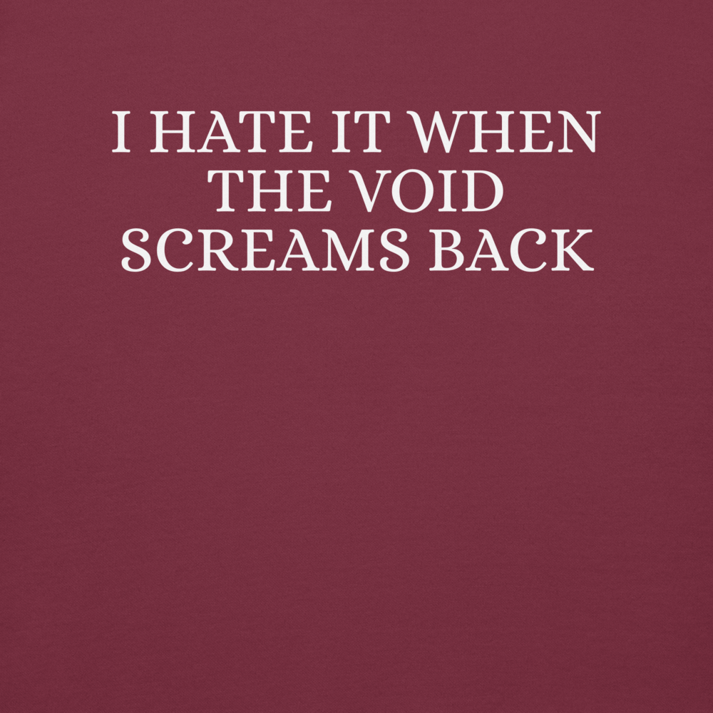 "I hate it when the void screams back" printed on a maroon background