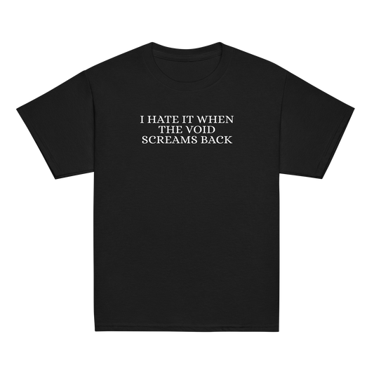 "I hate it when the void screams back" printed on a black youth classic tee laying on a flat surface