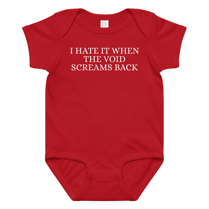 "I hate it when the void screams back" printed on a red baby jersey bodysuit laying on a flat surface amongst other clothes