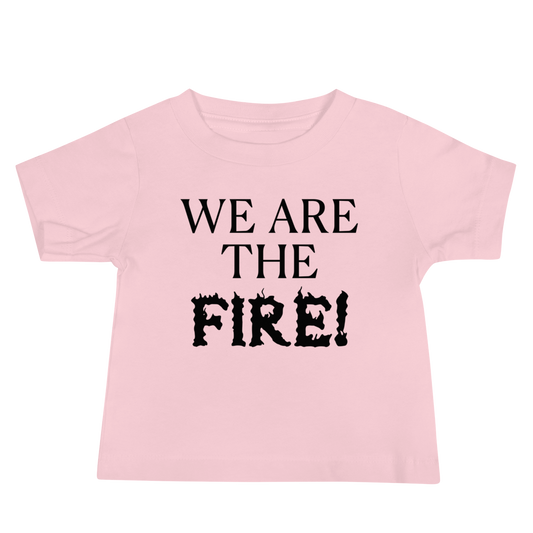 "We are the fire!" printed on a pink baby jersey short sleeve tee laying on a flat surface