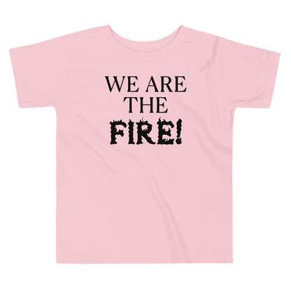 "We are the fire!" printed on a pink toddler short sleeve tee laying on a flat surface