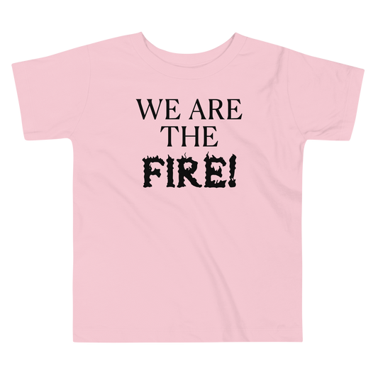 "We are the fire!" printed on a pink toddler short sleeve tee laying on a flat surface