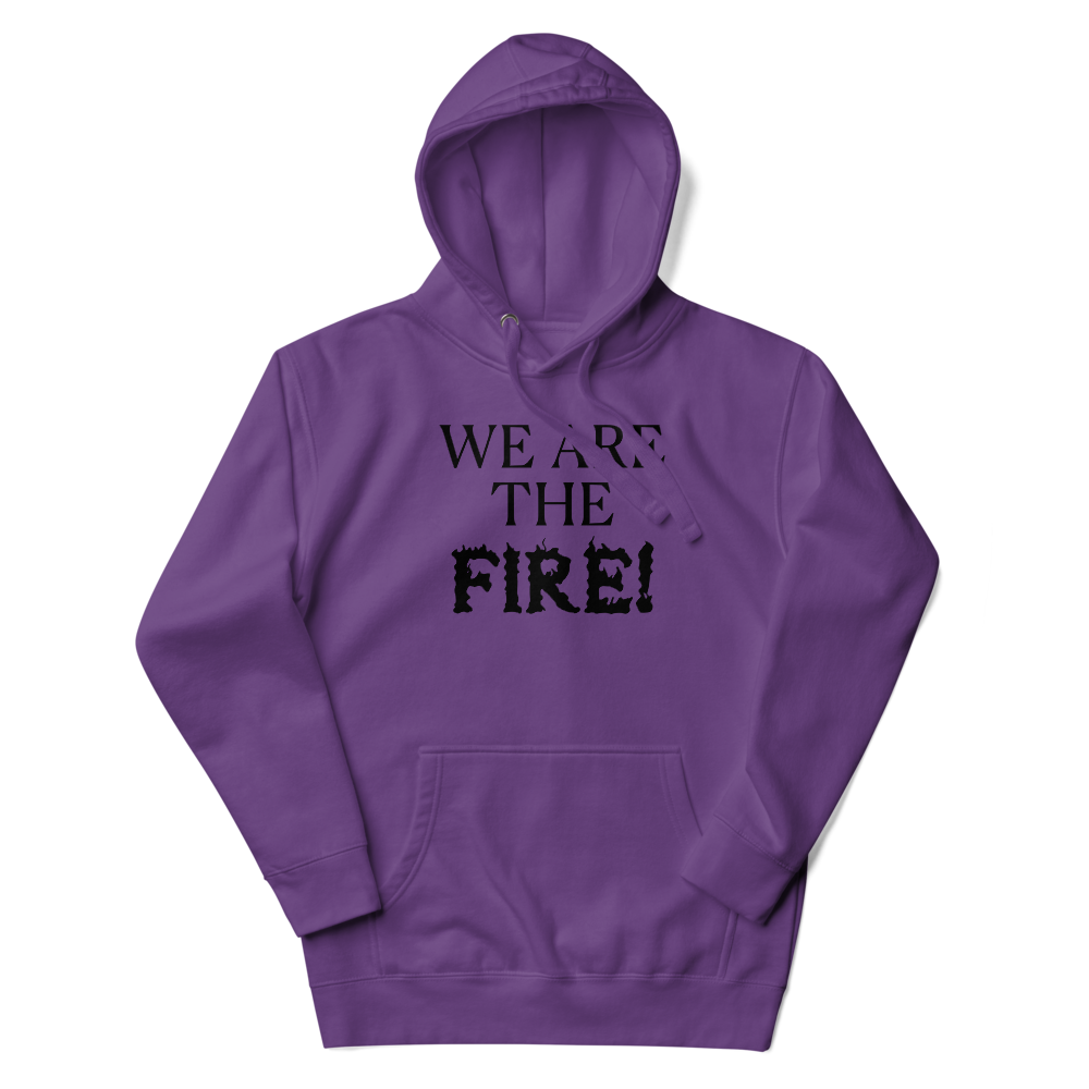 "We are the fire!" printed on a purple unisex hoodie laying on a flat surface with the hood up