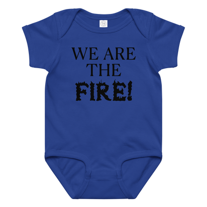 "We are the fire!" printed on a royal baby jersey bodysuit laying on a flat surface amongst other clothes