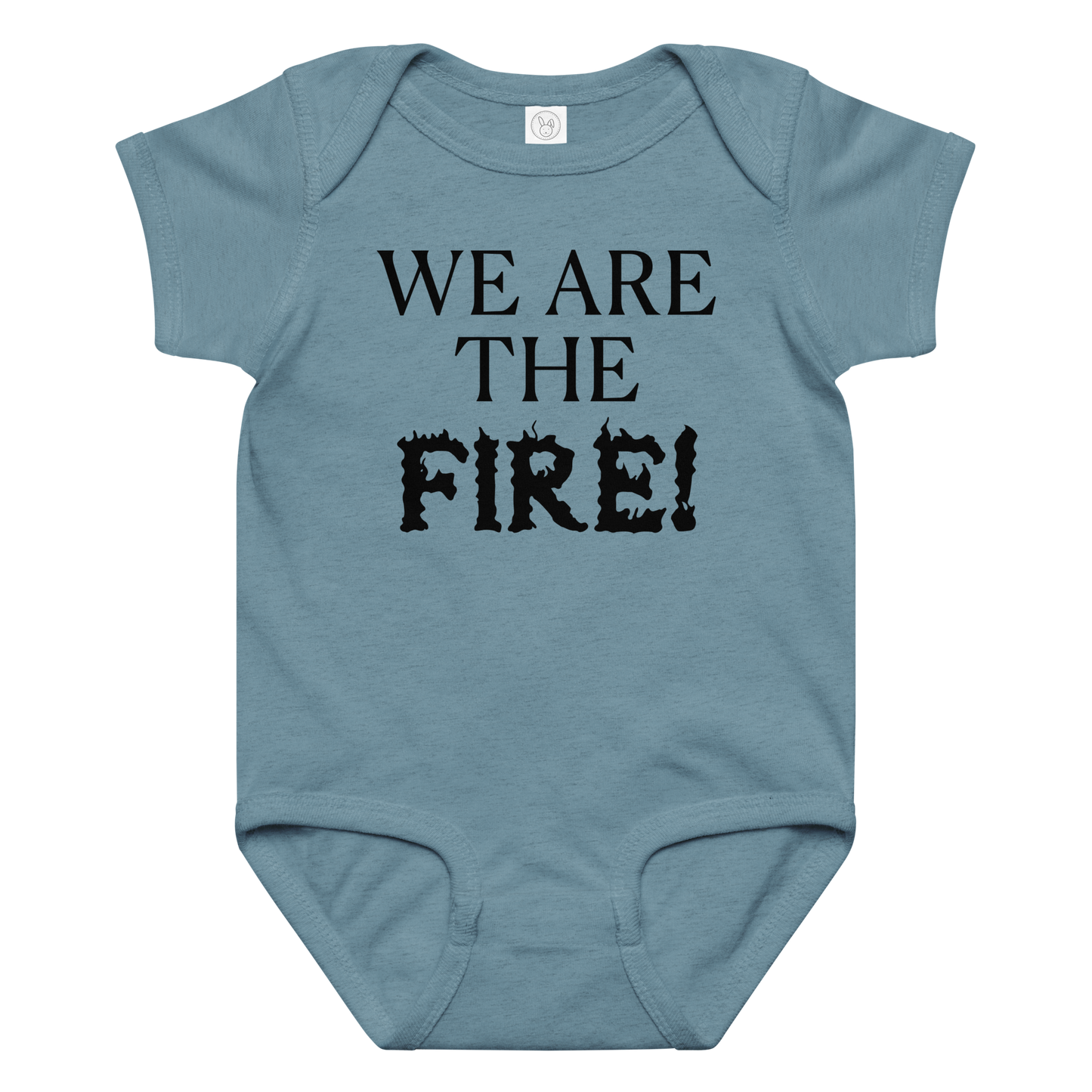 "We are the fire!" printed on a vintage indigo baby jersey bodysuit laying on a flat surface amongst other clothes