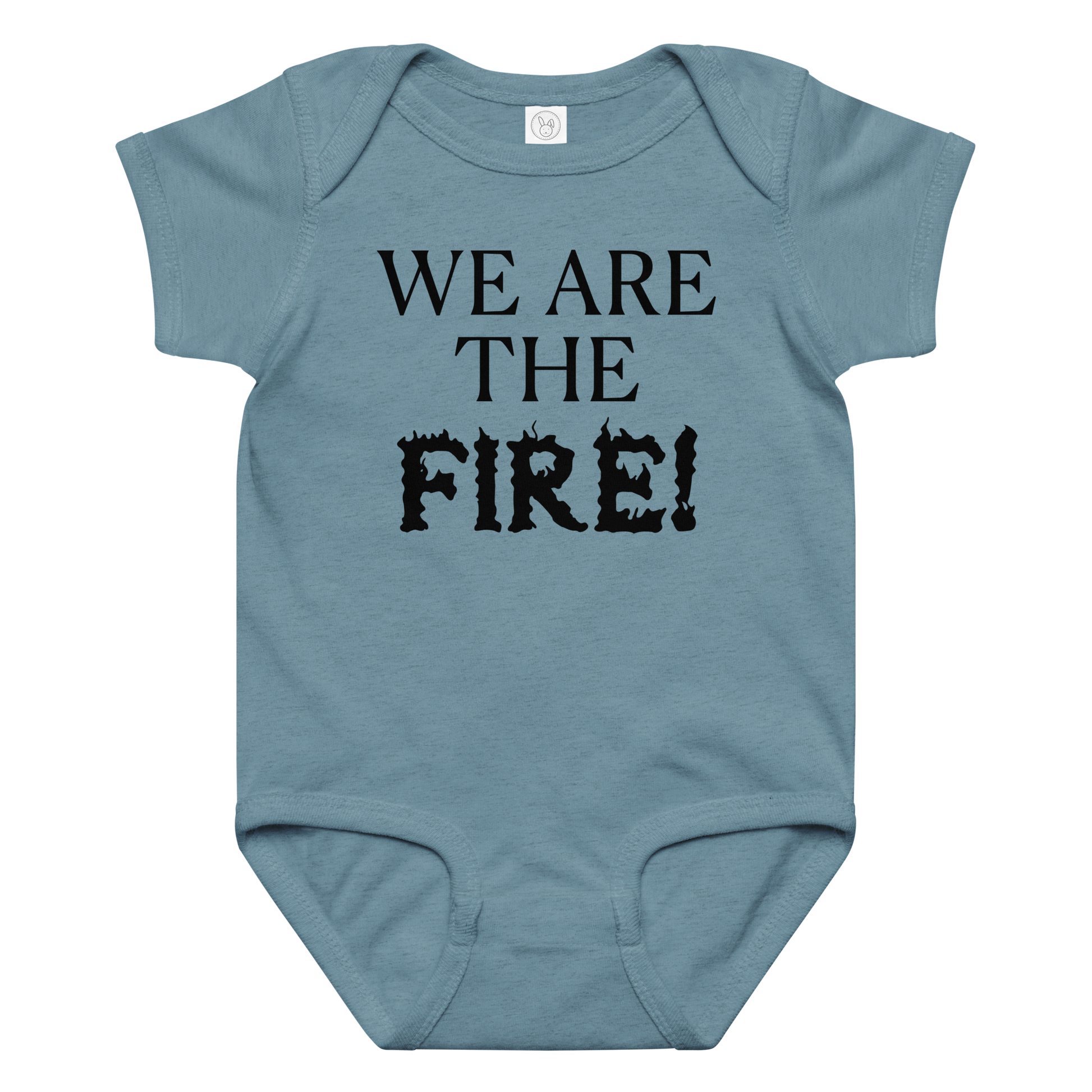 "We are the fire!" printed on a vintage indigo baby jersey bodysuit laying on a flat surface amongst other clothes
