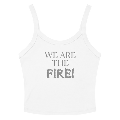 "We are the fire!" printed on a solid white blend women's micro-rib tanktop laying on a flat surface amongst sunglasses and shorts