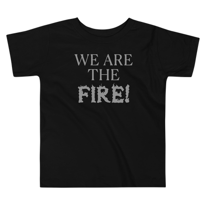 "We are the fire!" printed on a black toddler short sleeve tee laying on a flat surface