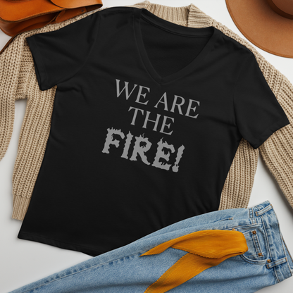 "We are the fire!" printed on a solid black blend women's relaxed v-neck t-shirt laying on a flat surface amongst other clothes