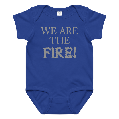 "We are the fire!" printed on a royal baby jersey bodysuit laying on a flat surface amongst other clothes