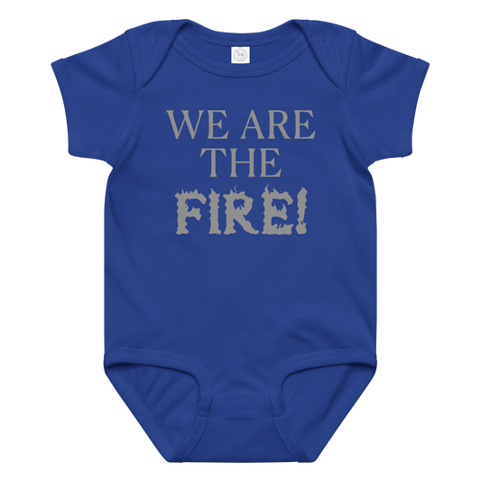 "We are the fire!" printed on a royal baby jersey bodysuit laying on a flat surface amongst other clothes