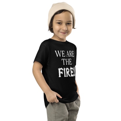 "We are the fire!" printed on a black toddler short sleeve tee worn by a male who is also wearing a knit cap