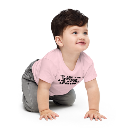 "We are the weird and we are legion" printed on a pink baby jersey short sleeve tee worn by a male who is crawling