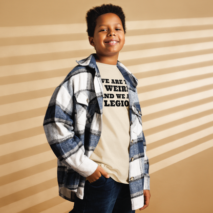 "We are the weird and we are legion" printed on a natural youth classic tee worn by a male also wearing a jacket