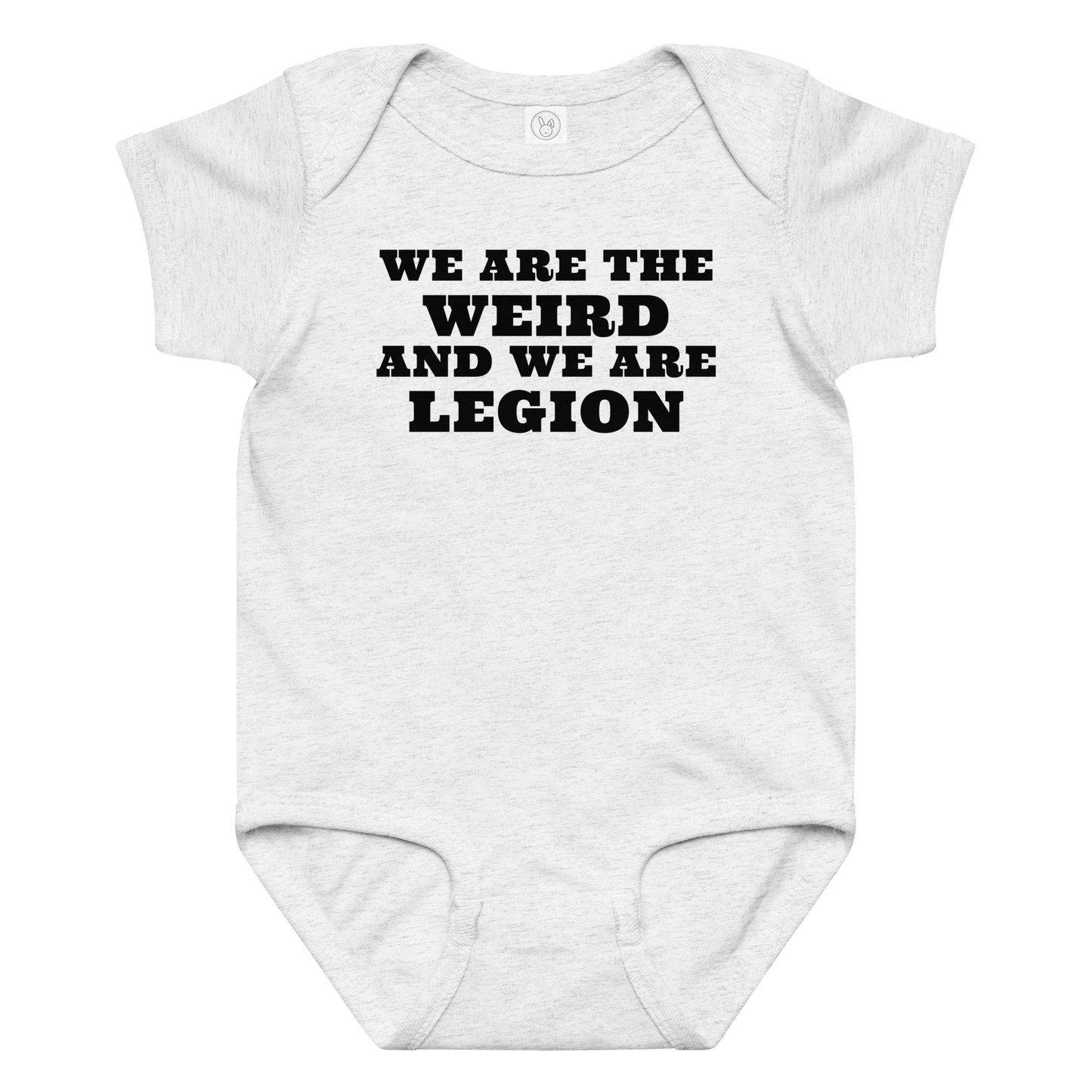 "We are the weird and we are legion" printed on a ash baby jersey bodysuit laying on a flat surface amongst other clothes