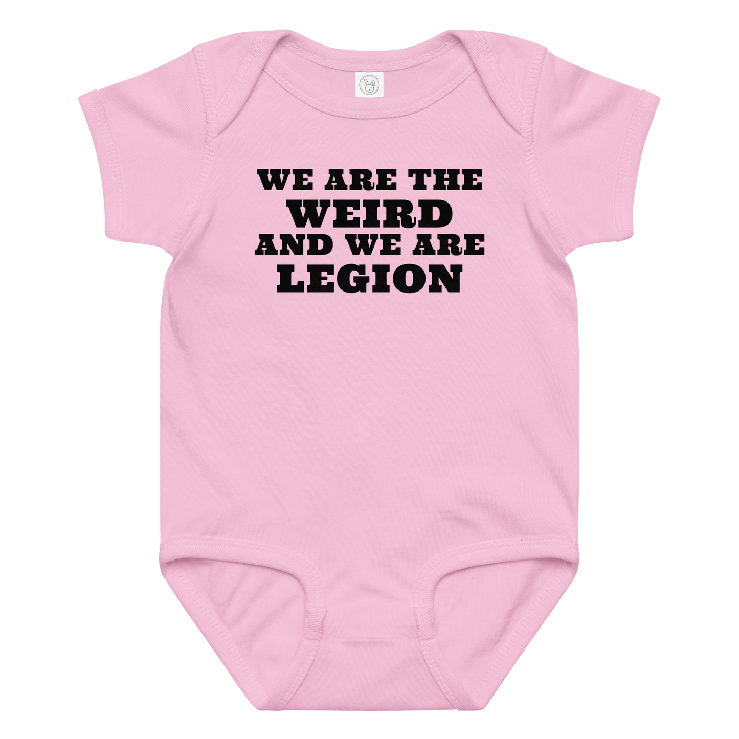 "We are the weird and we are legion" printed on a pink baby jersey bodysuit laying on a flat surface amongst other clothes