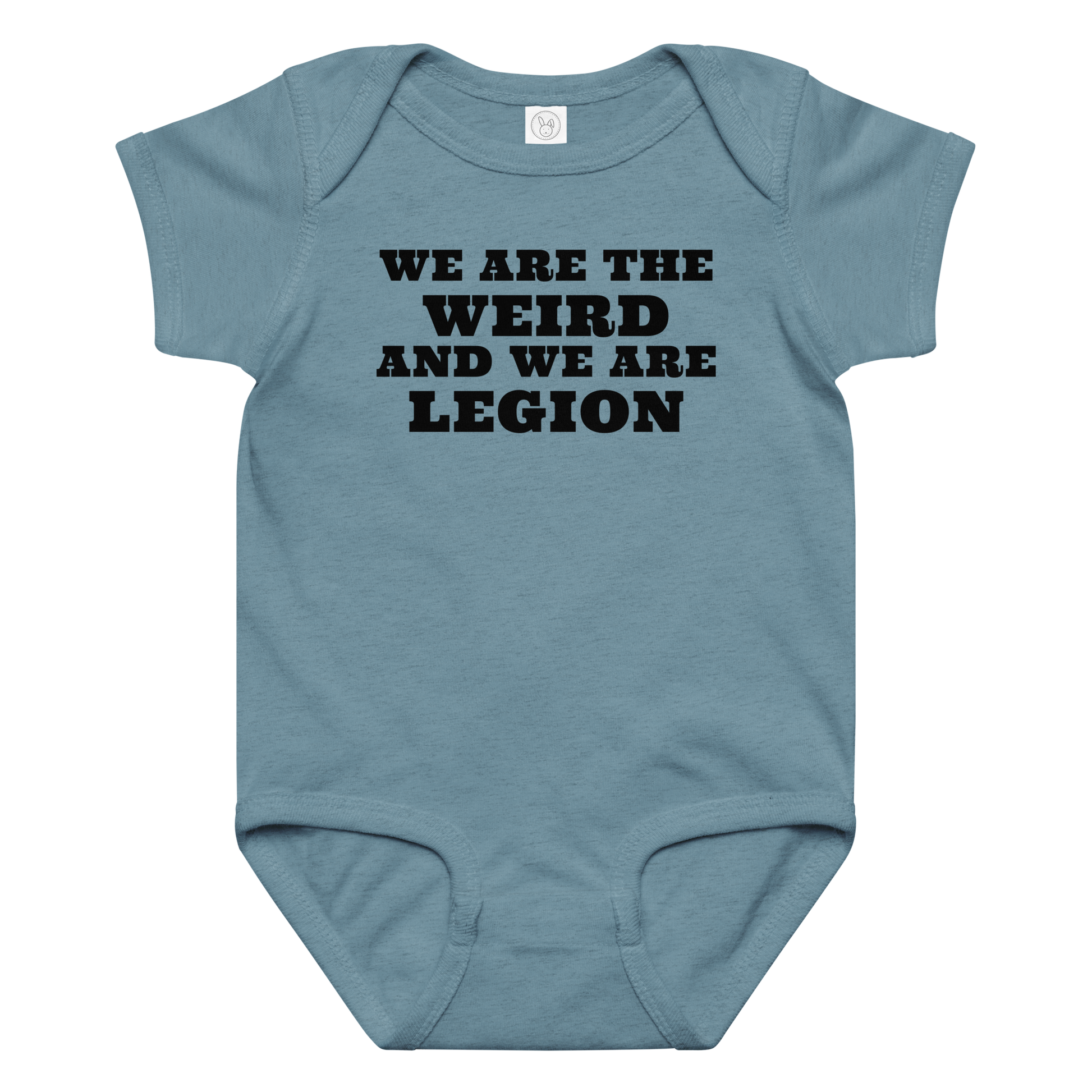 "We are the weird and we are legion" printed on a vintage indigo baby jersey bodysuit laying on a flat surface amongst other clothes