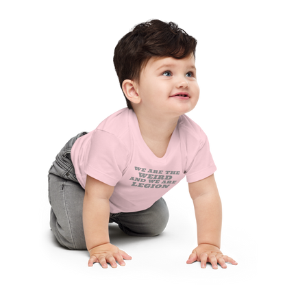 "We are the weird and we are legion" printed on a pink baby jersey short sleeve tee worn by a male who is crawling