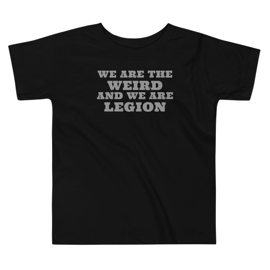 "We are the weird and we are legion" printed on a black toddler short sleeve tee laying on a flat surface