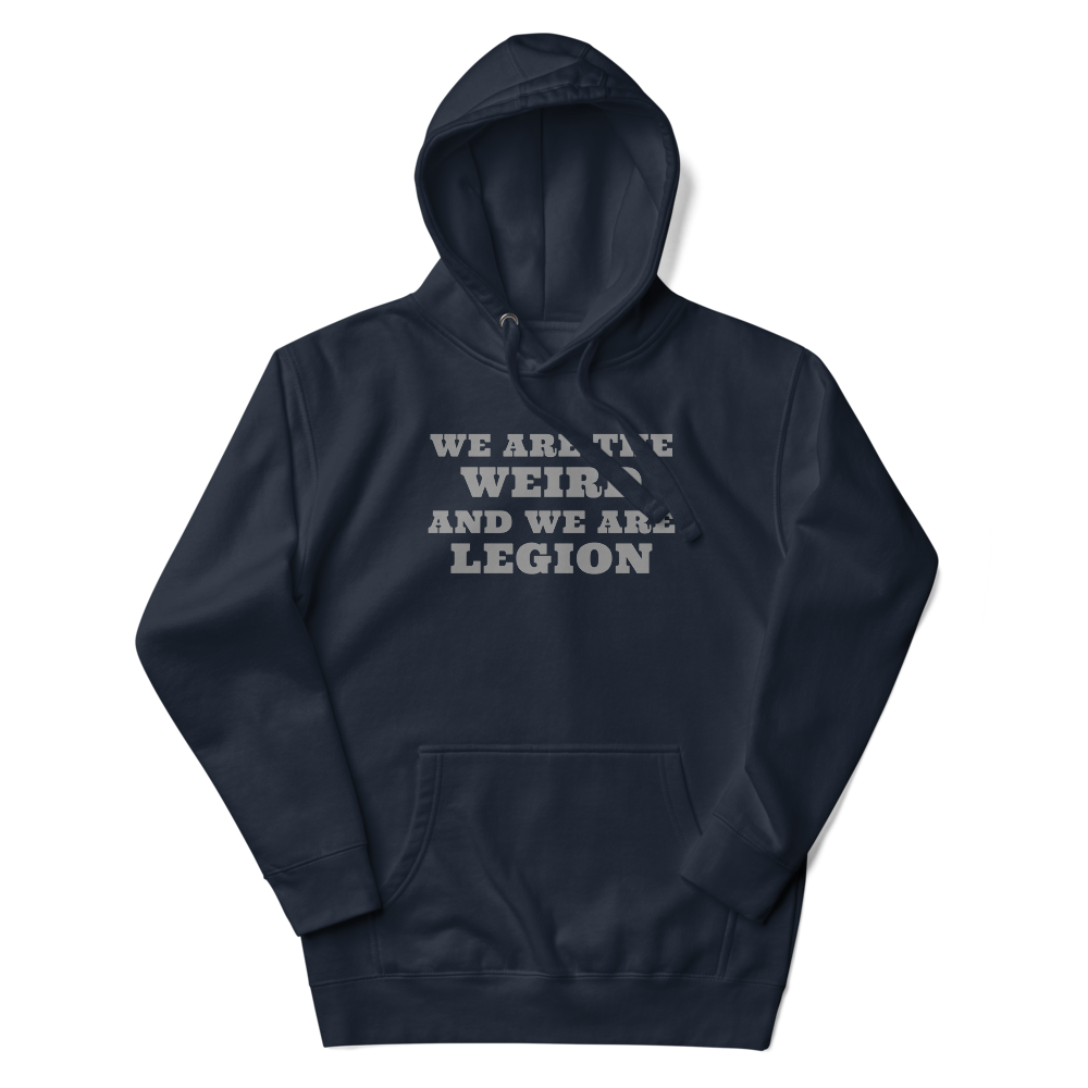 "We are the weird and we are legion" printed on a navy blazer unisex hoodie laying on a flat surface with the hood up