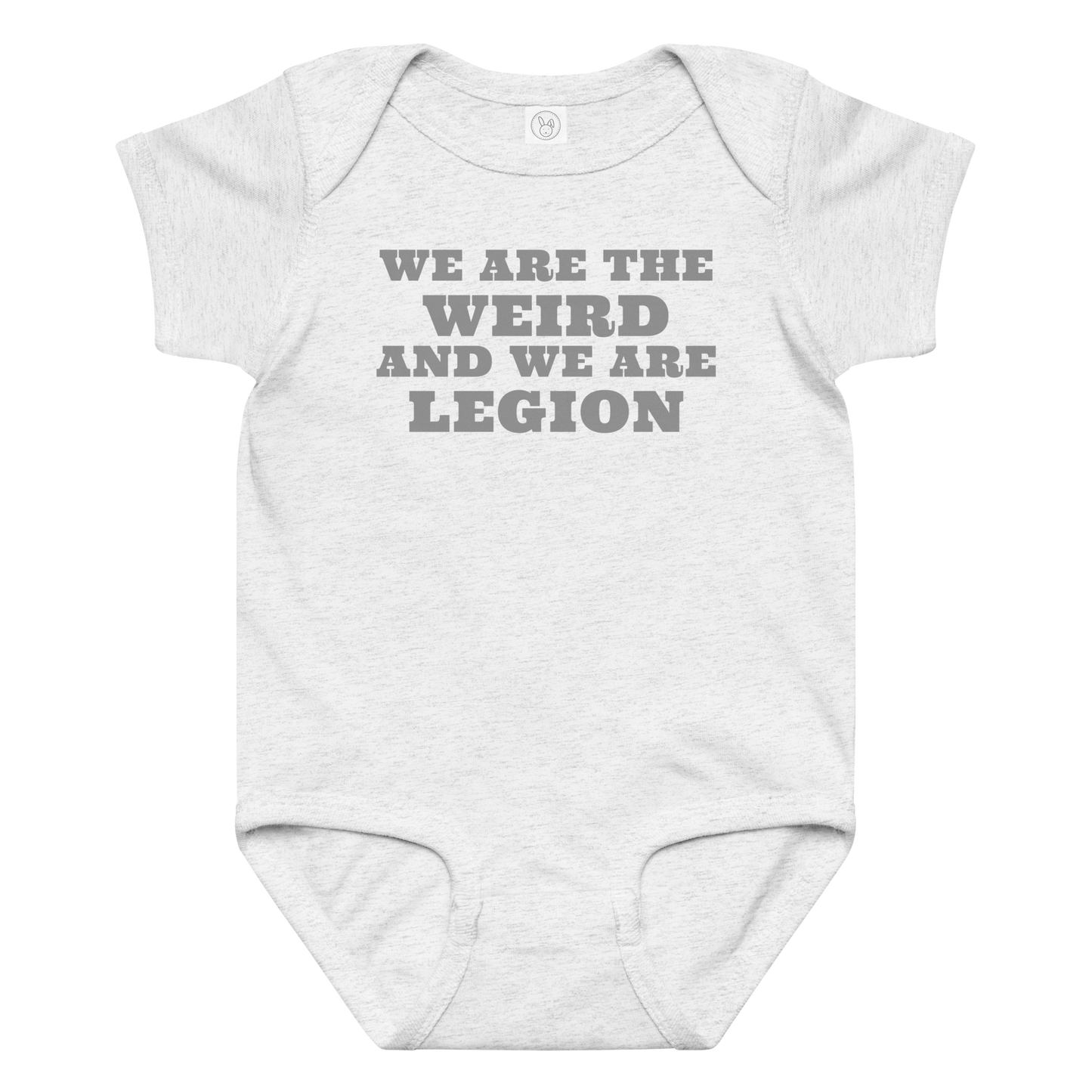 "We are the weird and we are legion" printed on a ash baby jersey bodysuit laying on a flat surface amongst other clothes