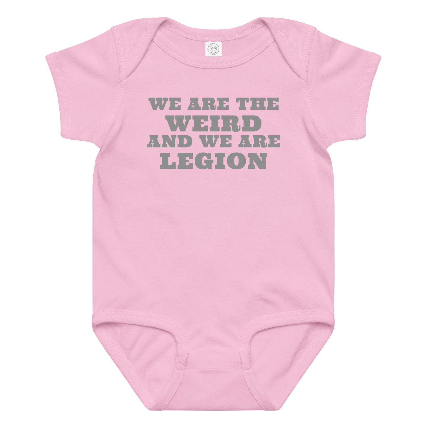 "We are the weird and we are legion" printed on a pink baby jersey bodysuit laying on a flat surface amongst other clothes