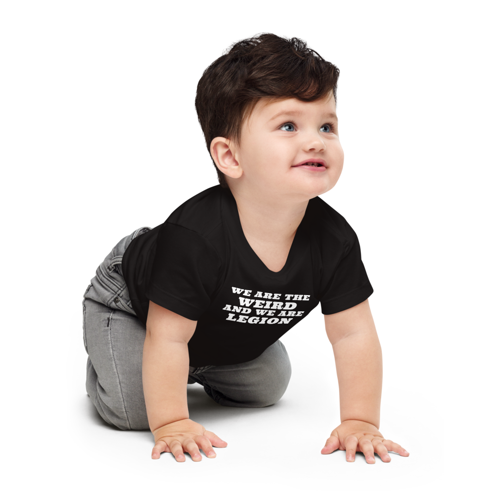 "We are the weird and we are legion" printed on a black baby jersey short sleeve tee worn by a male who is crawling