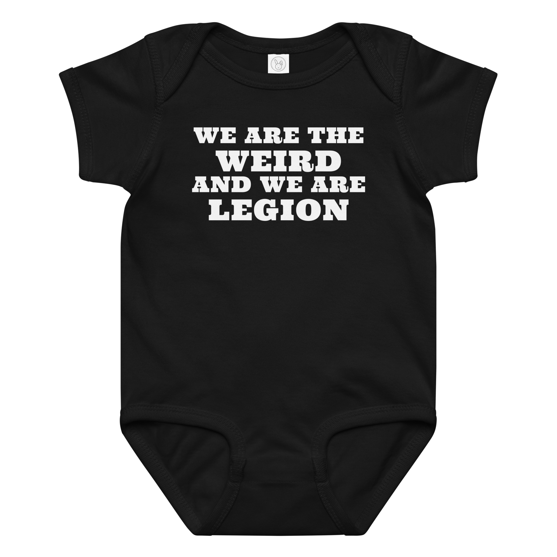 "We are the weird and we are legion" printed on a black baby jersey bodysuit laying on a flat surface amongst other clothes