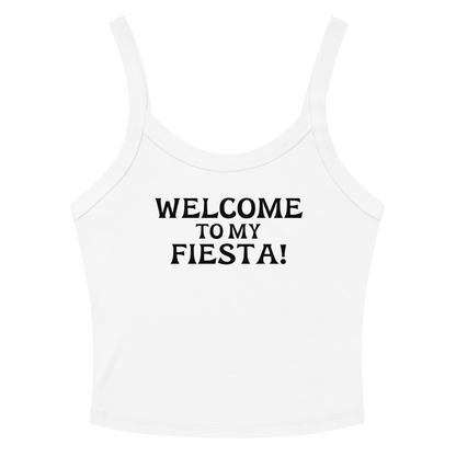 "Welcome to my fiesta!" printed on a solid white blend women's micro-rib tanktop laying on a flat surface amongst sunglasses and shorts