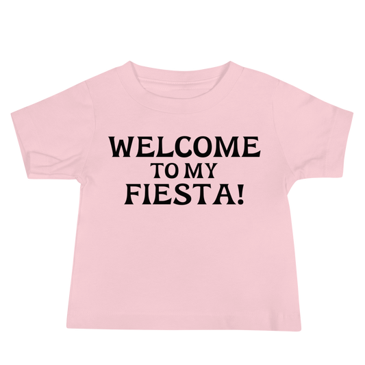 "Welcome to my fiesta!" printed on a pink baby jersey short sleeve tee laying on a flat surface