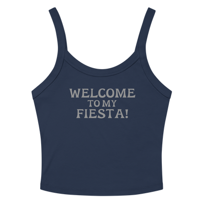 "Welcome to my fiesta!" printed on a solid navy blend women's micro-rib tanktop laying on a flat surface amongst sunglasses and shorts