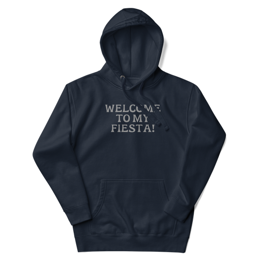"Welcome to my fiesta!" printed on a navy blazer unisex hoodie laying on a flat surface with the hood up