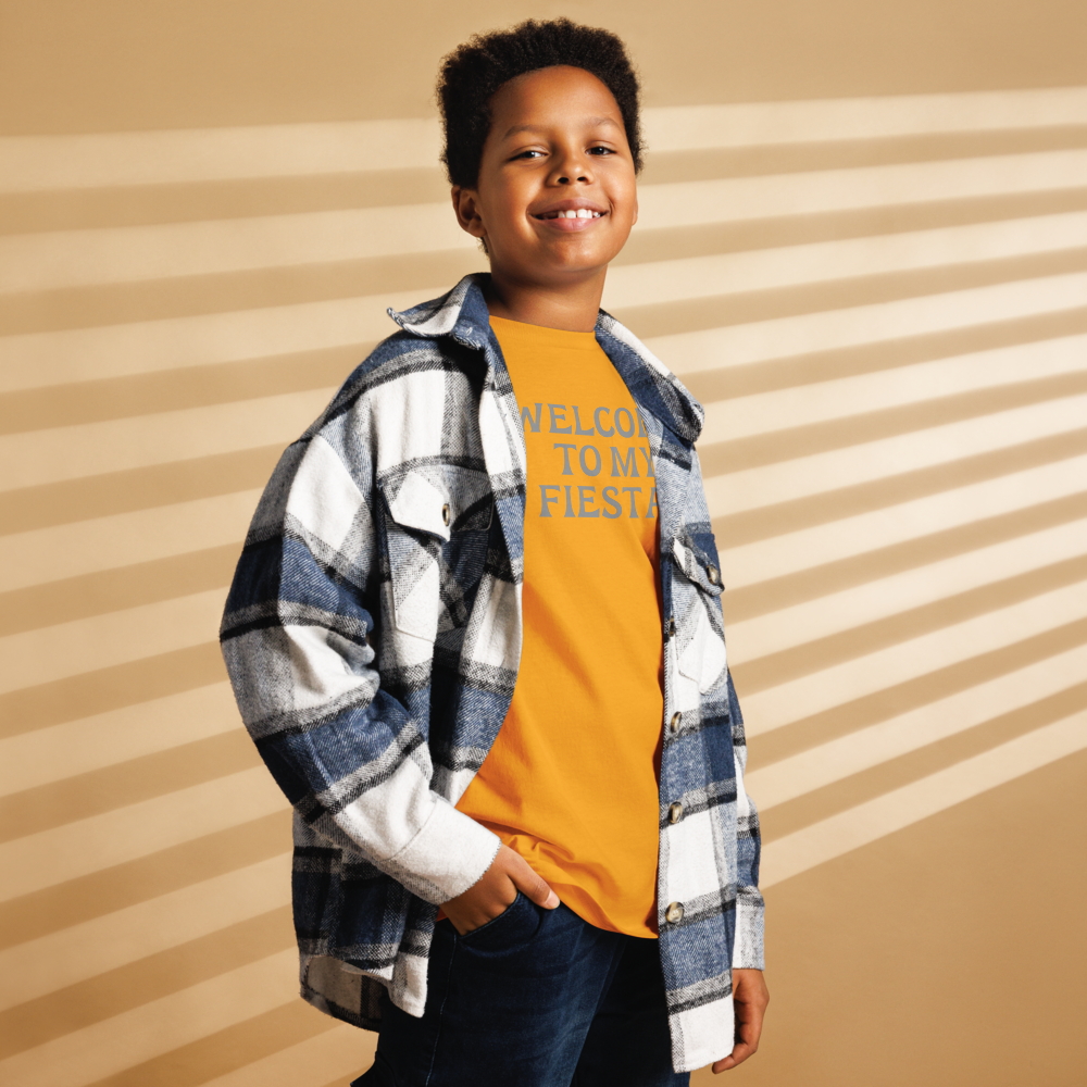 "Welcome to my fiesta!" printed on a gold youth classic tee worn by a male also wearing a jacket