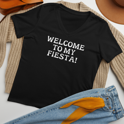 "Welcome to my fiesta!" printed on a solid black blend women's relaxed v-neck t-shirt laying on a flat surface amongst other clothes