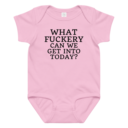 "What fuckery can we get into today?" printed on a pink baby jersey bodysuit laying on a flat surface amongst other clothes