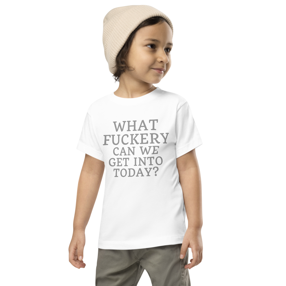 "What fuckery can we get into today?" printed on a white toddler short sleeve tee worn by a male wearing a cap