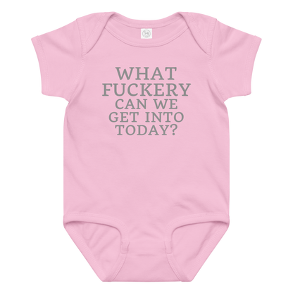 "What fuckery can we get into today?" printed on a pink baby jersey bodysuit laying on a flat surface amongst other clothes
