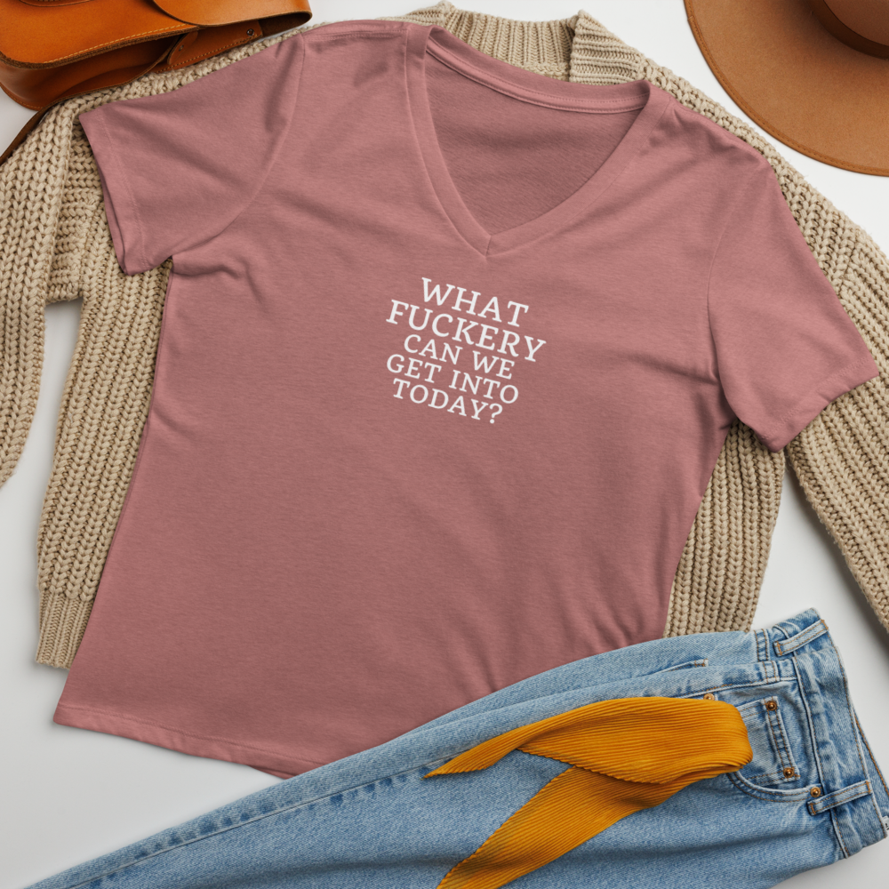 "What fuckery can we get into today?" printed on a heather mauve women's relaxed v-neck t-shirt laying on a flat surface amongst other clothes