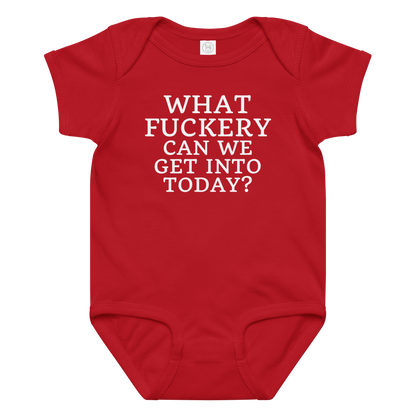 "What fuckery can we get into today?" printed on a red baby jersey bodysuit laying on a flat surface amongst other clothes
