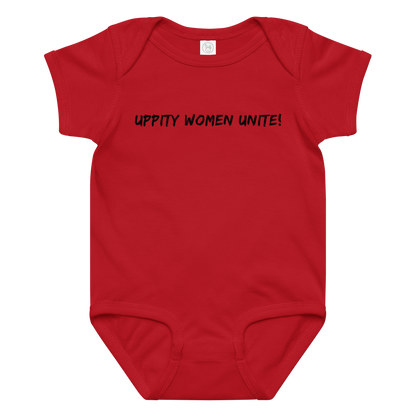 "Uppity Women Unite" printed on a red baby jersey bodysuit laying on a flat surface amongst other clothes