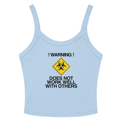 "!Warning! Does Not Work Well With Others" printed on a solid baby blue blend women's micro-rib tanktop laying on a flat surface amongst sunglasses and shorts