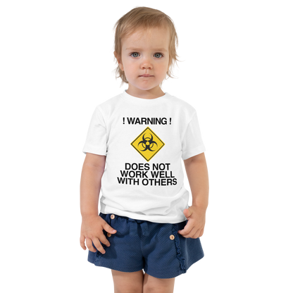 "!Warning! Does Not Work Well With Others" printed on a white toddler short sleeve tee worn by a female