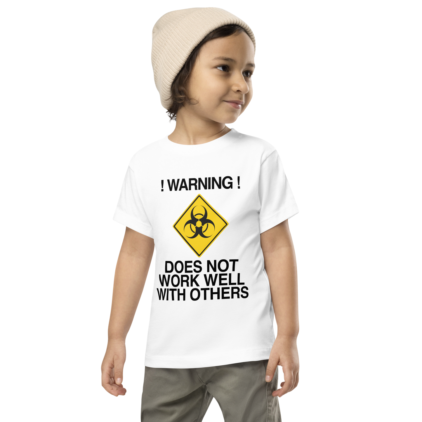 "!Warning! Does Not Work Well With Others" printed on a white toddler short sleeve tee worn by a male wearing a cap
